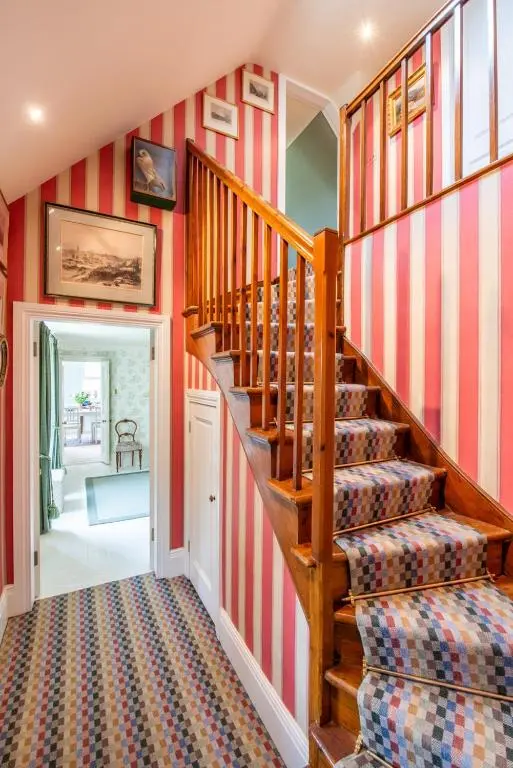 a staircase in a home with red and white stripes at Dun Brae Cottage in Dornoch