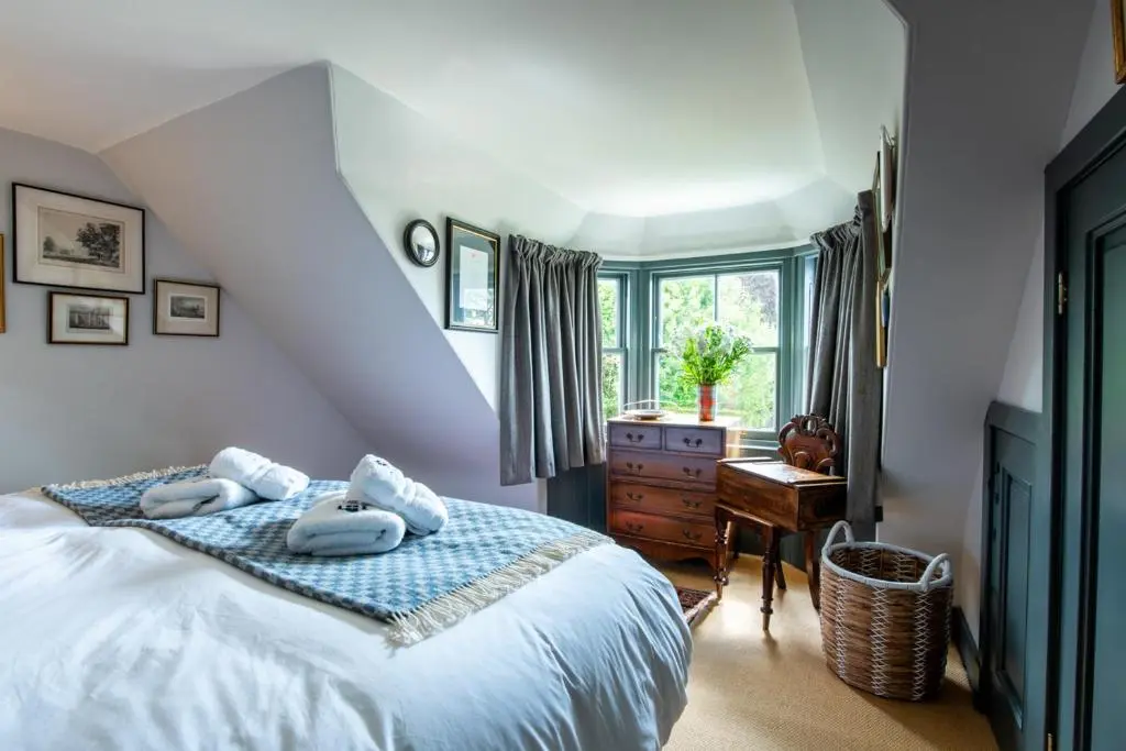 a bedroom with a bed with towels on it at Dun Brae Cottage in Dornoch