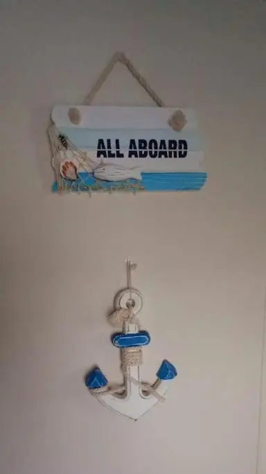 a sign that says all aboard hanging on a wall at Coral Cove in Lossiemouth