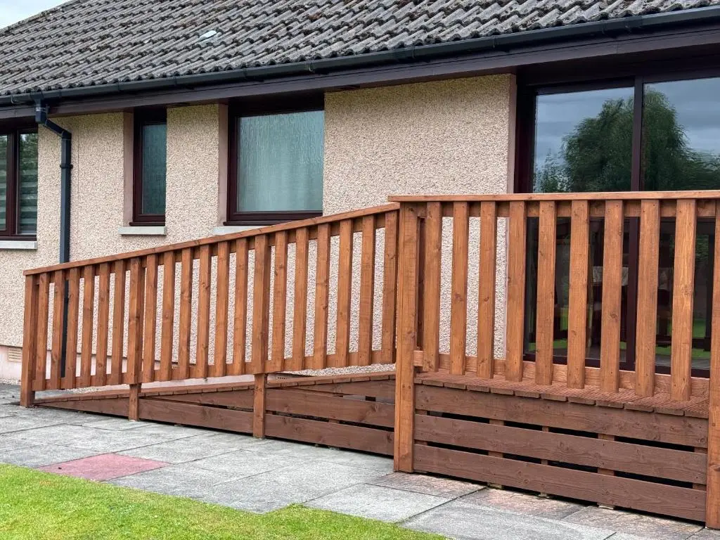 a wooden fence in front of a house at Oaklyn,Highland Village of Beauly, Quiet Neighbourhood, One Bed, Min 5 nights in Beauly