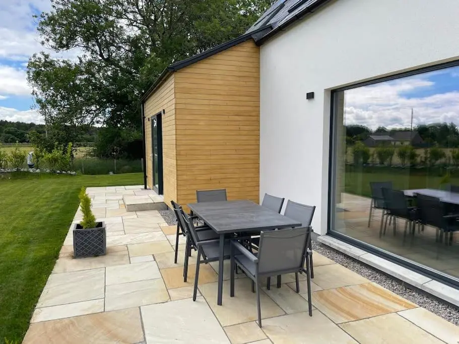 a patio with a table and chairs in a yard at Ash Mill - Dornoch in Dornoch