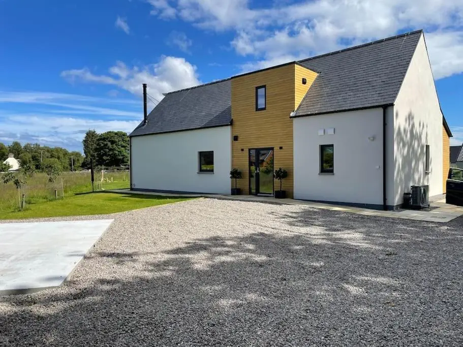 a large white and yellow house with a driveway at Ash Mill - Dornoch in Dornoch