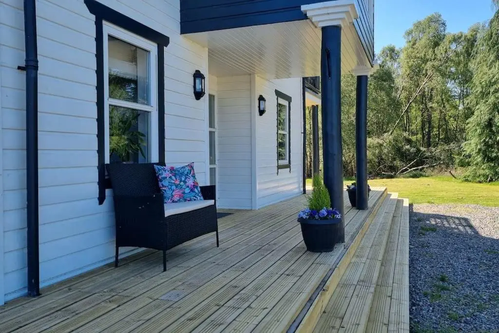 a porch with a chair on a house at Heath House Loch Ness in Errogie