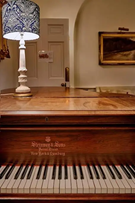 a piano with a lamp on top of it at Idyllic 12 bedroom Country Home in Forres