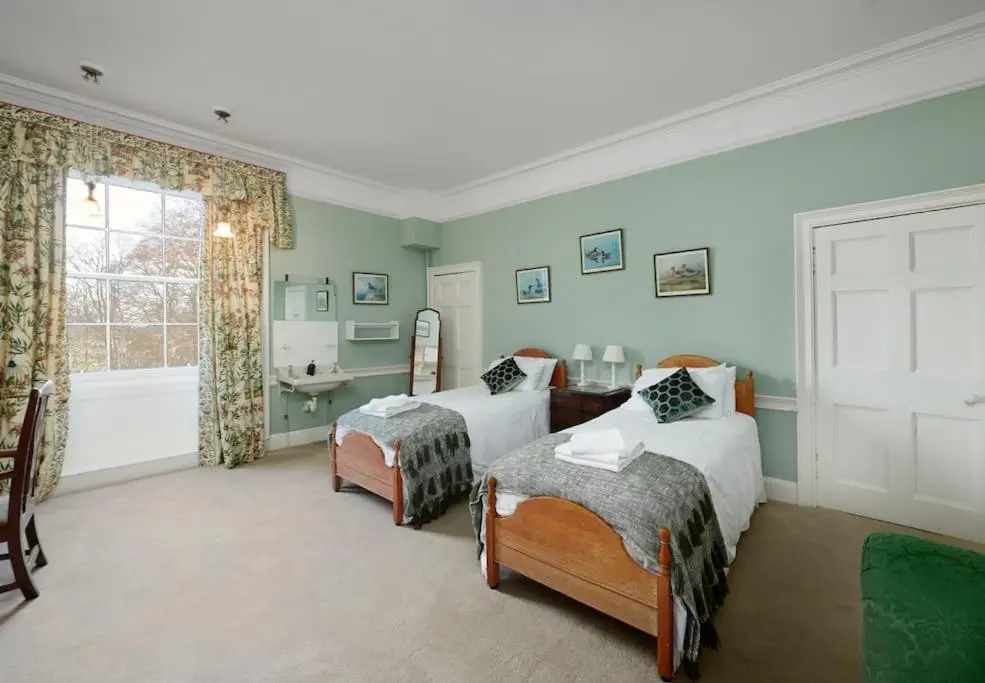 a bedroom with two beds and a sink and a tub at Idyllic 12 bedroom Country Home in Forres