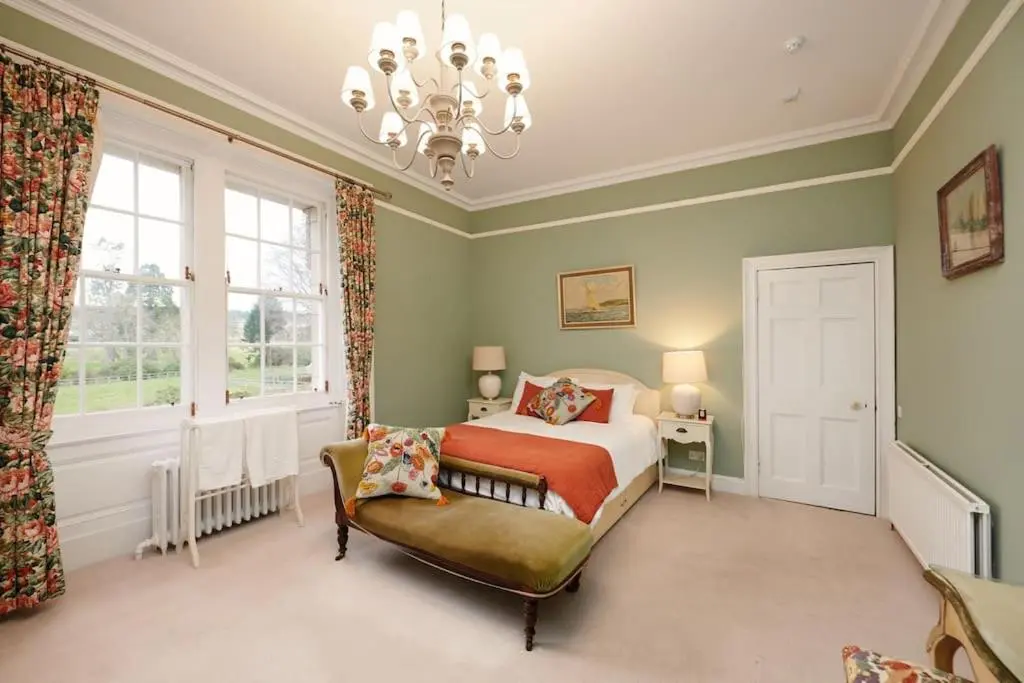a bedroom with a bed and a chandelier at Idyllic 12 bedroom Country Home in Forres