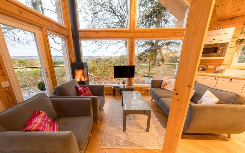 a living room with couches and a table at Cherry Tree Lodge in Inverness