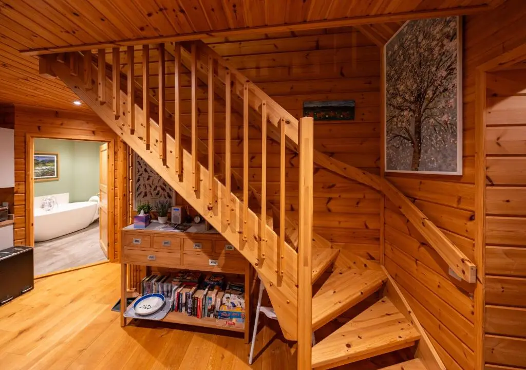 a wooden staircase in a log cabin at Cherry Tree Lodge in Inverness