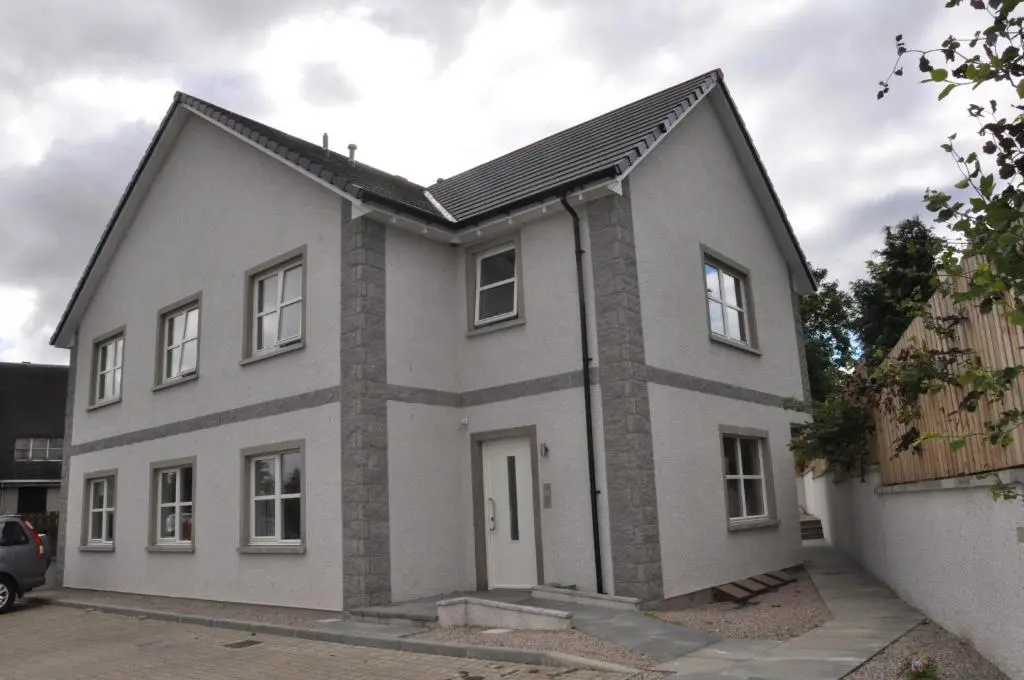 a white house with a gray roof at Westgate Apartments Birchlee in Inverurie