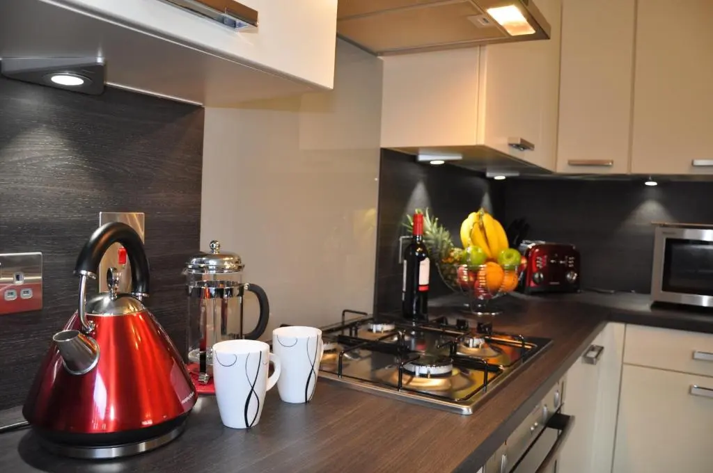 a kitchen with a red tea kettle on a counter at Westgate Apartments Birchlee in Inverurie