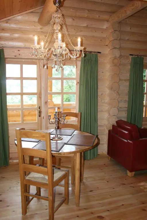 a dining room with a table and a chandelier at BCC Loch Ness Log Cabins in Bearnock