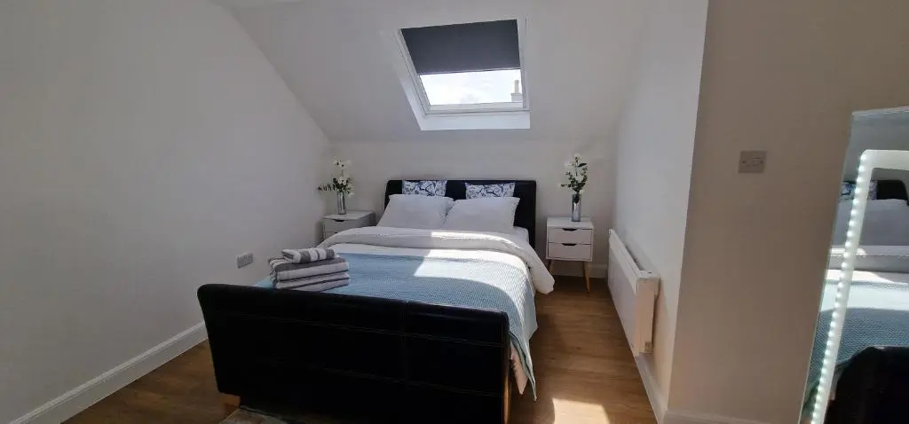 a small bedroom with two beds and a window at The Flat at Clocktower Buildings in Kinloss