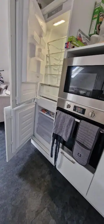 an empty refrigerator with its door open in a kitchen at The Flat at Clocktower Buildings in Kinloss