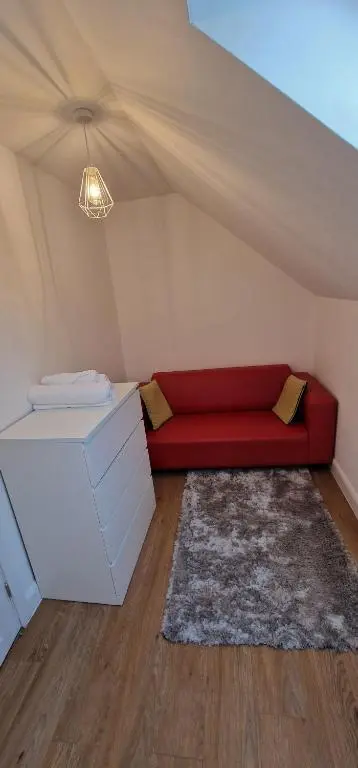 a living room with a red couch in a tent at The Flat at Clocktower Buildings in Kinloss