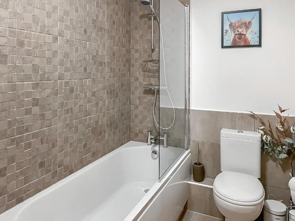 a bathroom with a tub and a toilet and a shower at No 8 Cottage in Aviemore