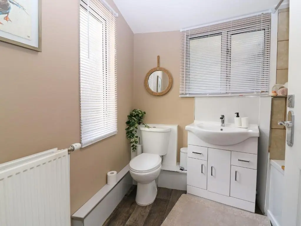 a bathroom with a toilet and a sink at West Pier Cottage in Macduff