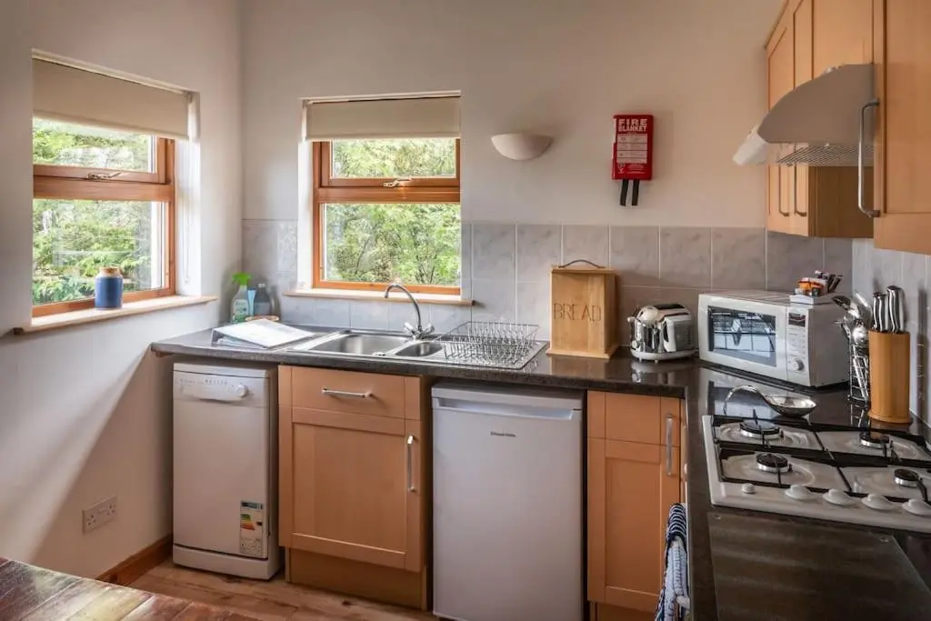 a kitchen with a sink and a stove top oven at Findhorn Bay - Sandpiper Eco chalet in Findhorn