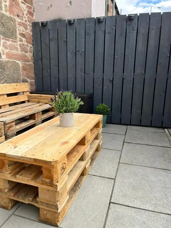a wooden pallet table with a potted plant on a patio at 23 Innes Street Apartment in Inverness