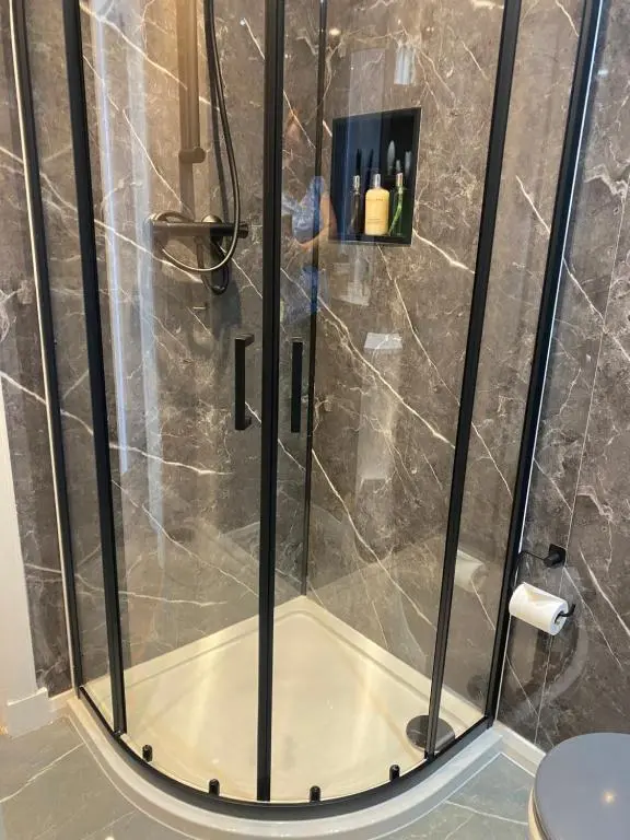 a shower with a glass door in a bathroom at 23 Innes Street Apartment in Inverness