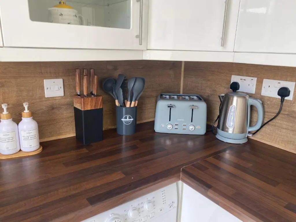 a kitchen counter top with a coffee maker and utensils at 23 Innes Street Apartment in Inverness