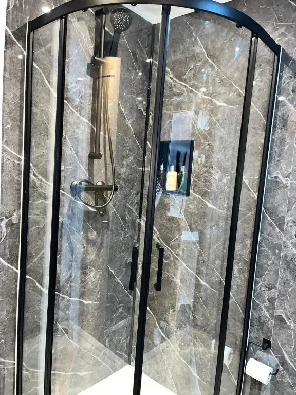a shower with a glass door in a bathroom at 23 Innes Street Apartment in Inverness