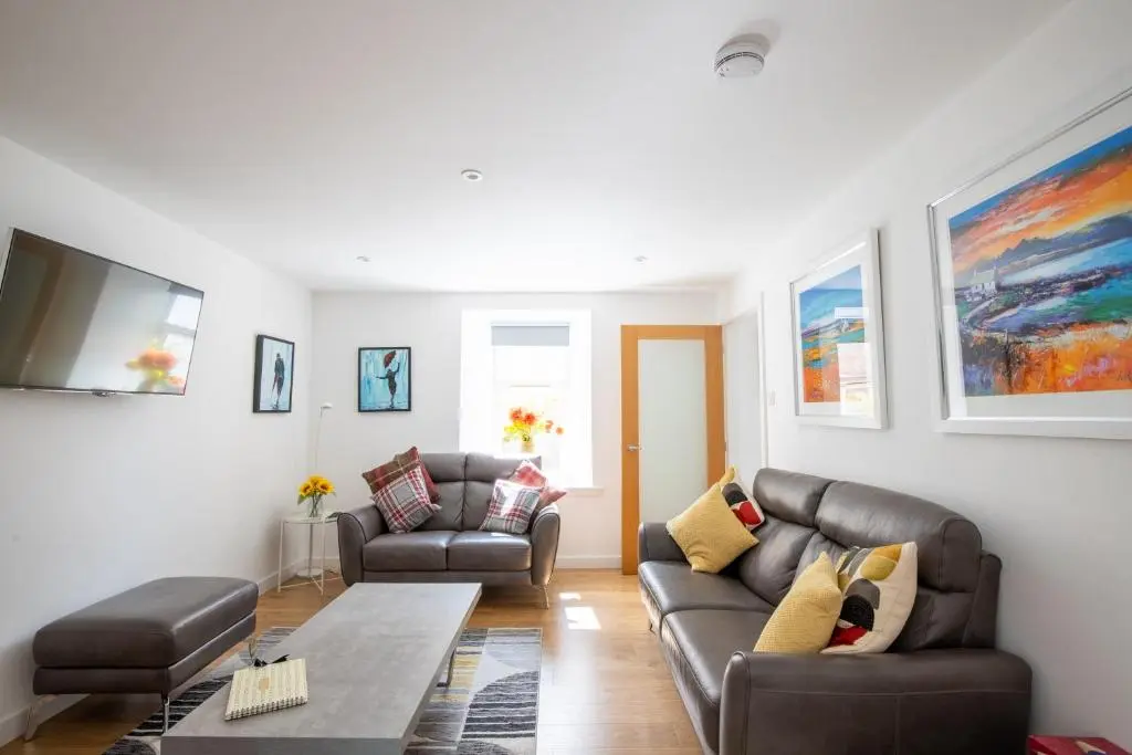 a living room with a couch and a table at Cairnie Cottage in Ballater