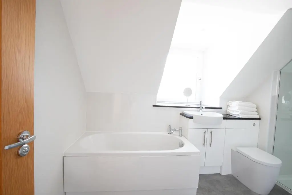 a white bathroom with a sink and a toilet at Cairnie Cottage in Ballater