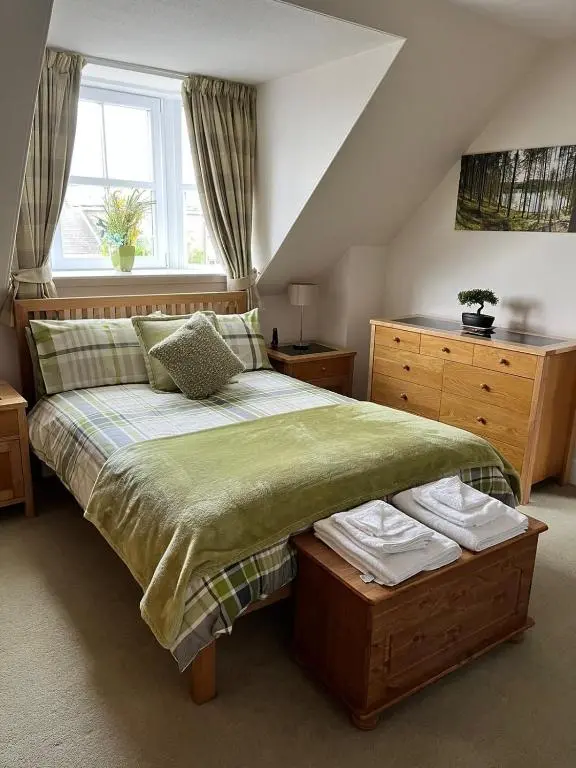a bedroom with a large bed and a window at The Nairn House in Nairn