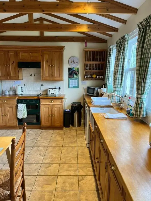 a kitchen with wooden cabinets and a counter top at The Nairn House in Nairn