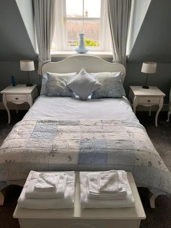 a bedroom with a large bed with two tables at The Nairn House in Nairn