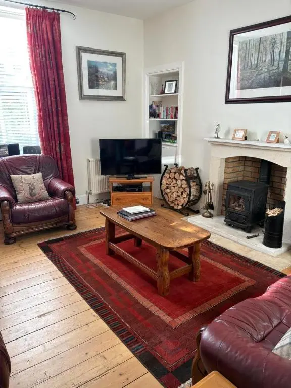 a living room with a coffee table and a fireplace at The Nairn House in Nairn