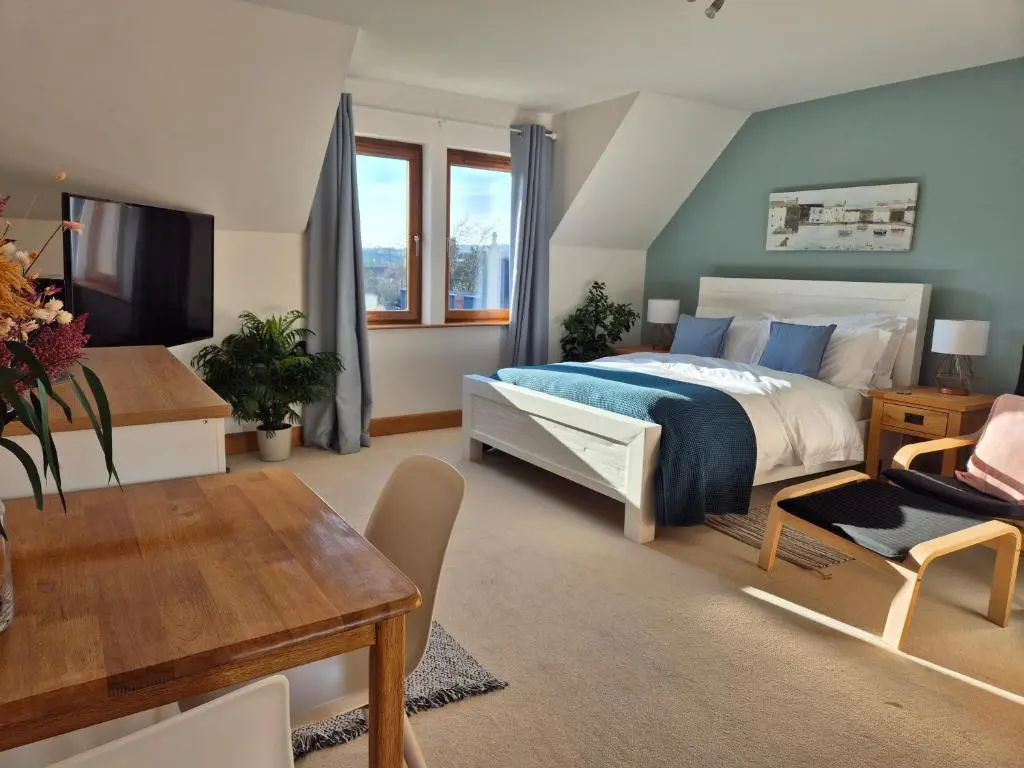 a bedroom with a large bed and a table at Twin Pines in Mulben