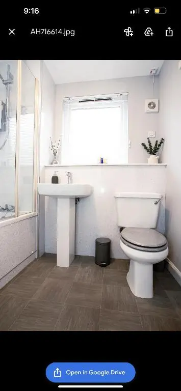 a bathroom with a toilet and a sink and a window at Inverness Apartment - Uist in Inverness