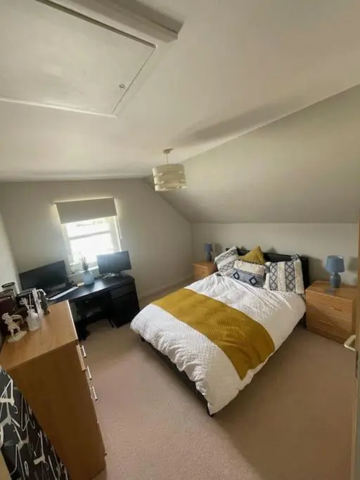a bedroom with a bed and a desk in it at Inverurie Town Centre 97m2 Maisonette in Inverurie