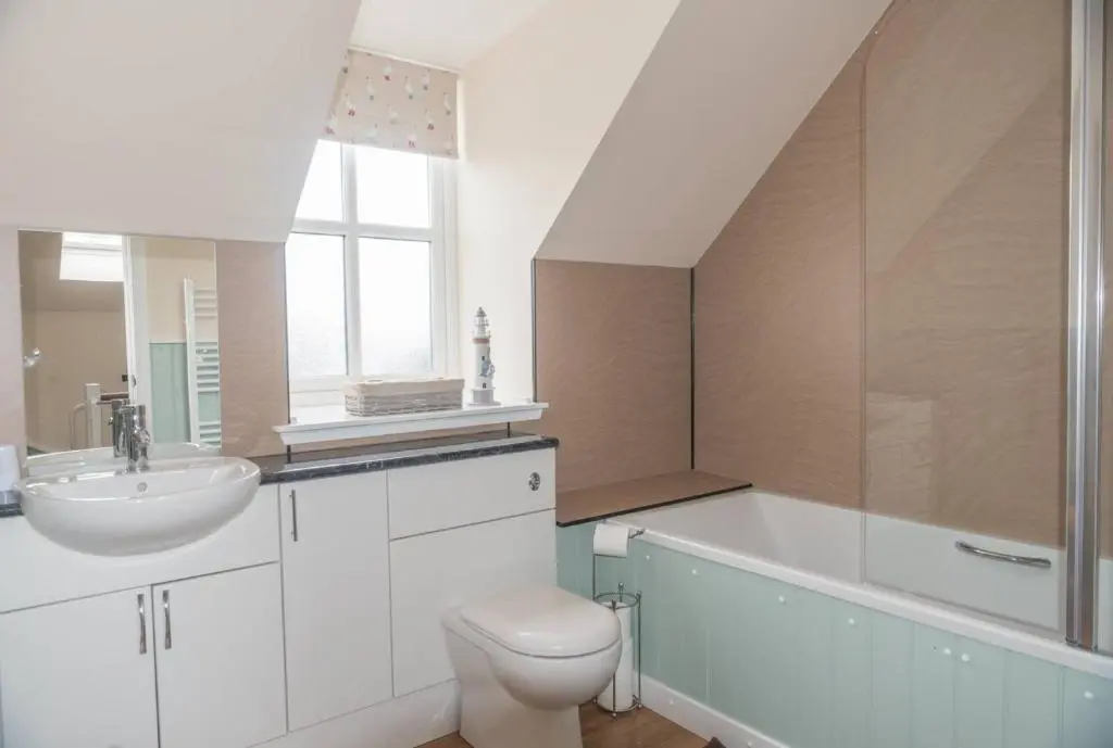 a white bathroom with a sink and a toilet at Cosy Spacious Highland Cottage in Craggie