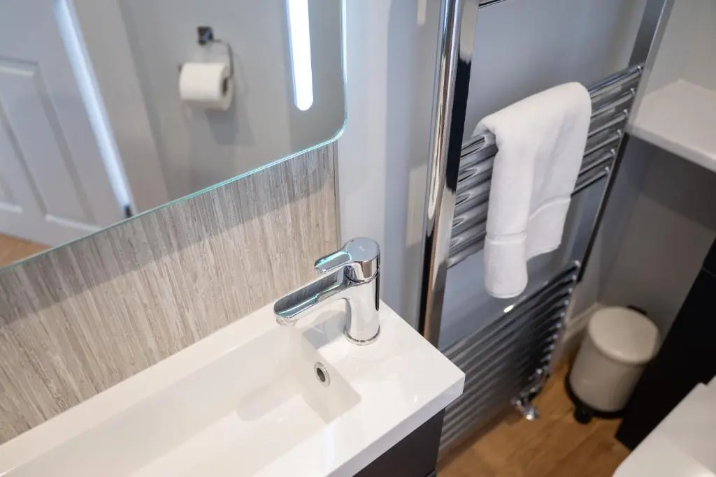 a bathroom with a white sink and a mirror at Hillside Luxury Apartments in Inverness