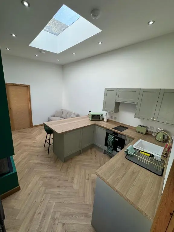 a large kitchen with a skylight in the ceiling at Cosy Luxury apartment in Wick