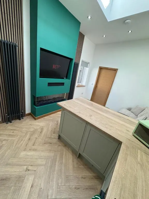 a living room with a table and a tv at Cosy Luxury apartment in Wick