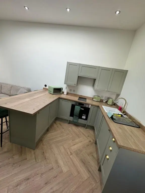 a kitchen with a wooden counter top in a room at Cosy Luxury apartment in Wick