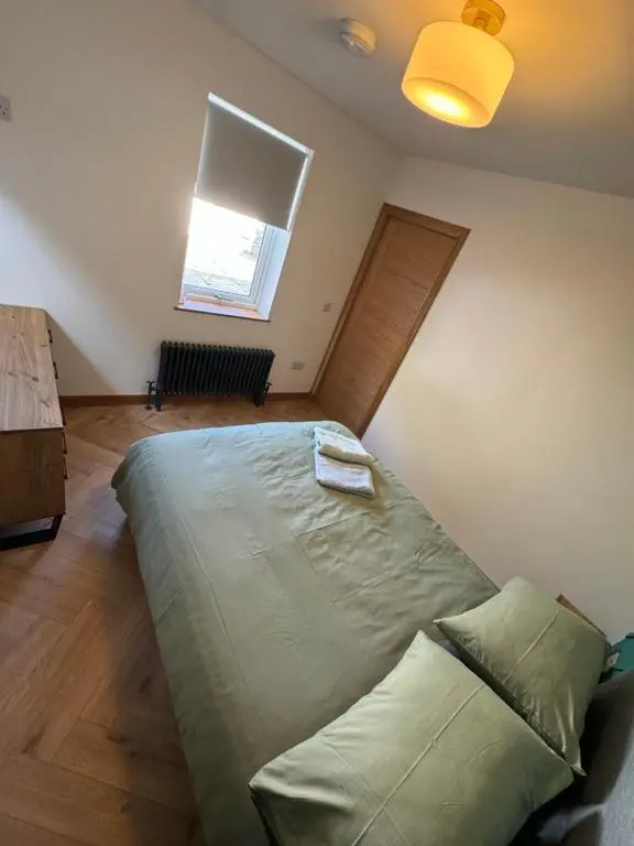 a bedroom with a large bed with a window at Cosy Luxury apartment in Wick