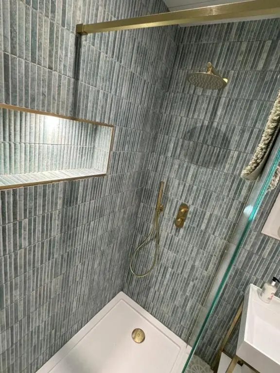 a bathroom with a shower with a toilet and a sink at Cosy Luxury apartment in Wick