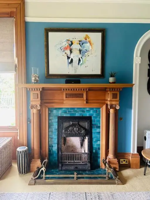 a living room with a fireplace with a painting above it at Victorian Home in Moray in Forres