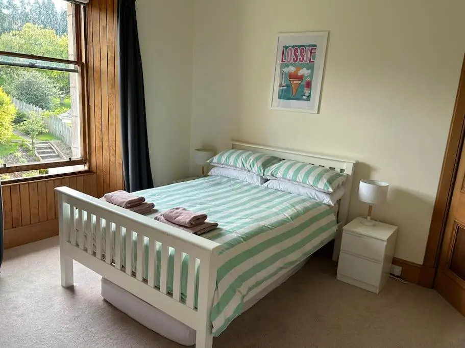 a small bedroom with a bed with a window at Victorian Home in Moray in Forres