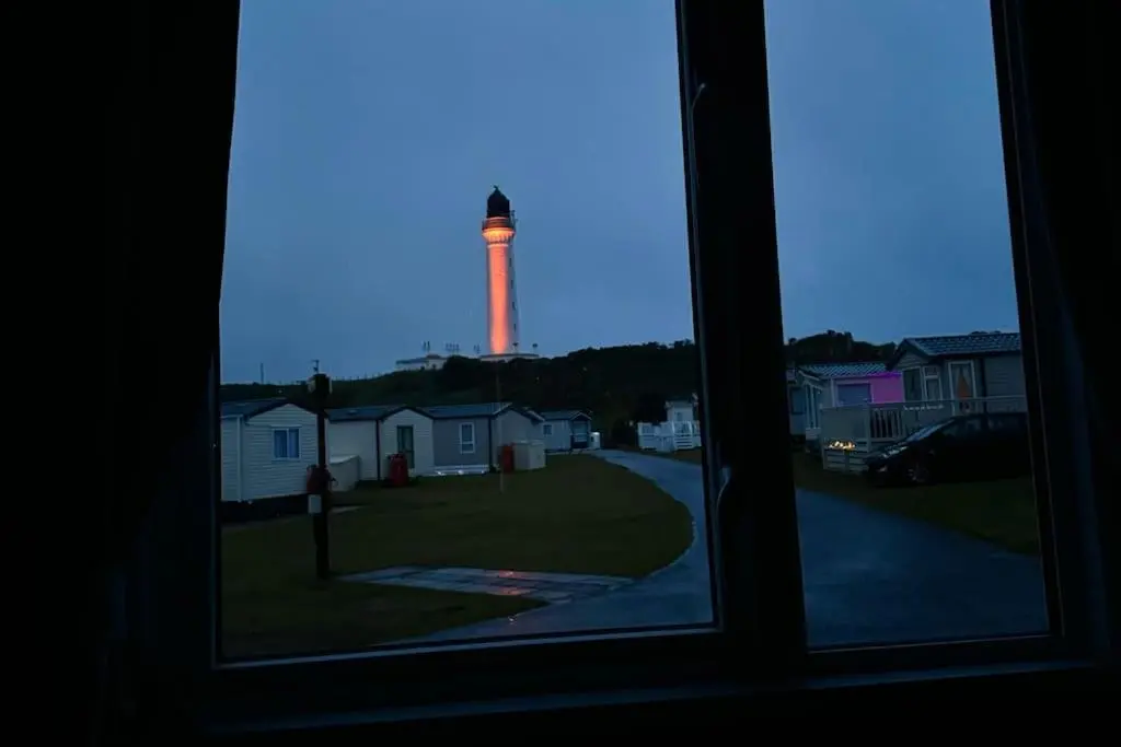 a view of a lighthouse from a window at Sea La Vie Caravan at Silver Sands Holiday Park in Lossiemouth