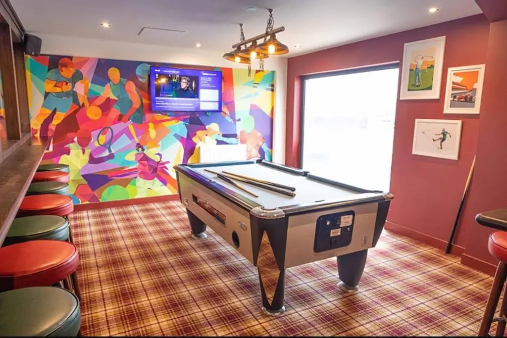 a room with a pool table and a colorful wall at Sea La Vie Caravan at Silver Sands Holiday Park in Lossiemouth