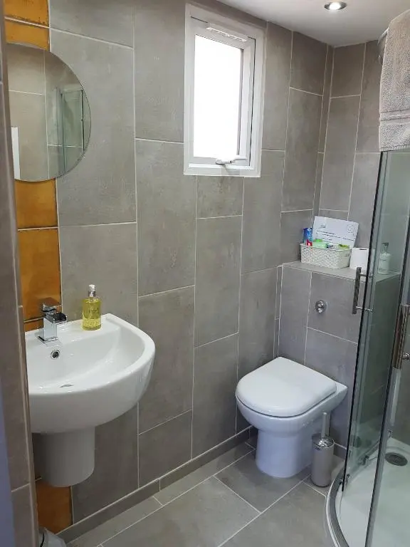 a bathroom with a sink and a toilet and a window at Highland Rooms - Room Only No Breakfast in Ullapool
