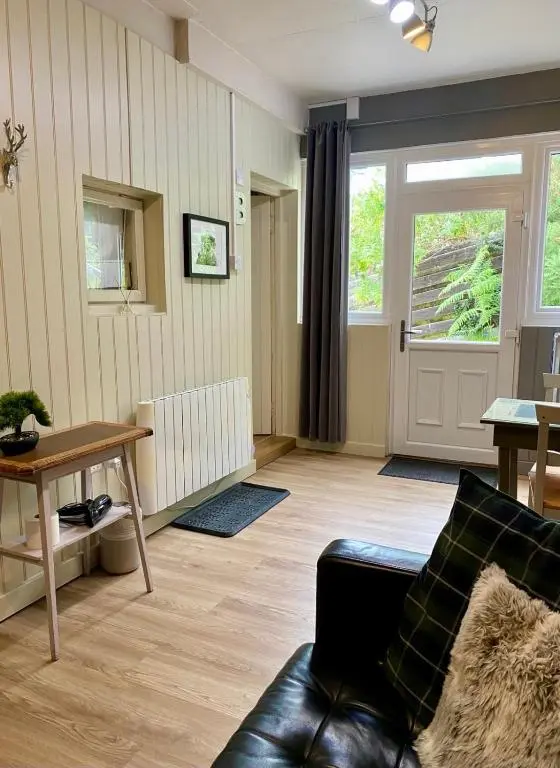 a living room with a couch and a table at Highland Rooms - Room Only No Breakfast in Ullapool