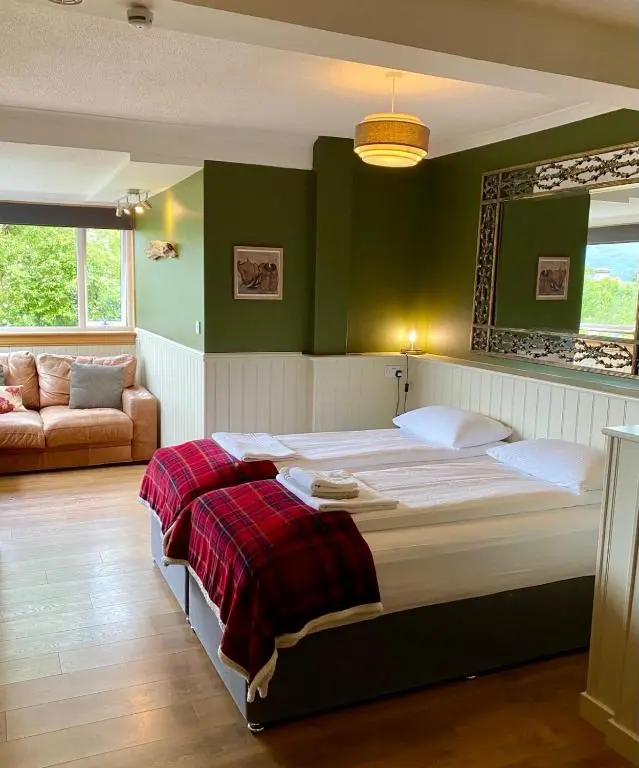 a bedroom with a large bed and a couch at Highland Rooms - Room Only No Breakfast in Ullapool