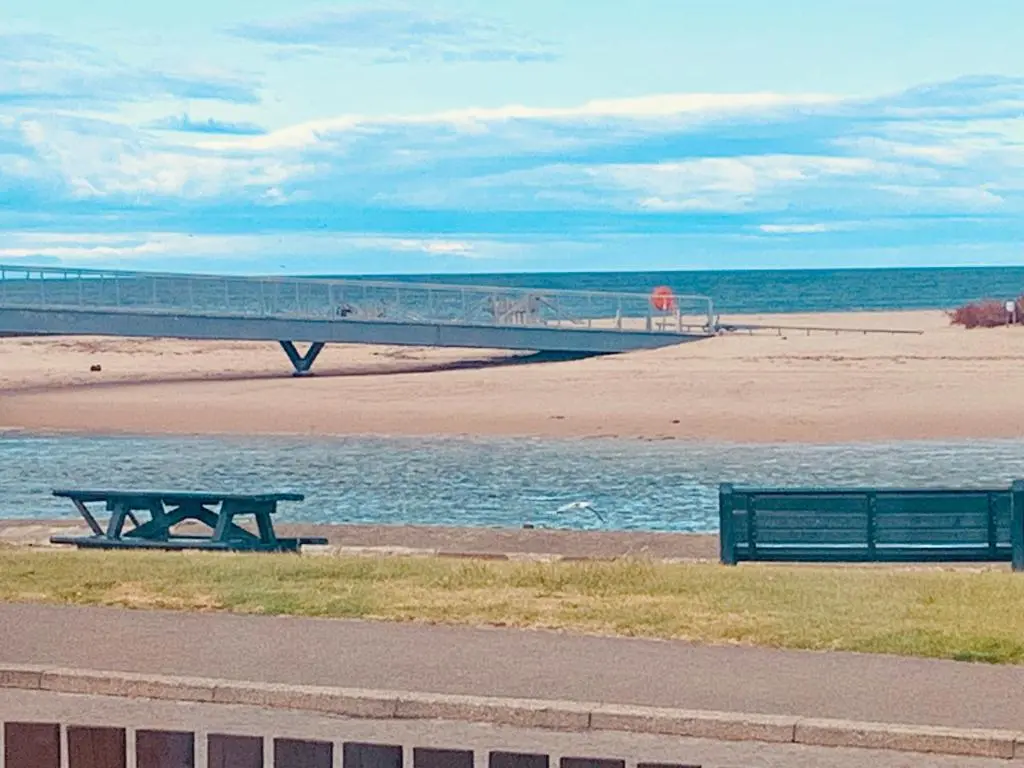 a picnic table and a bench on the beach at The Annexe in Lossiemouth