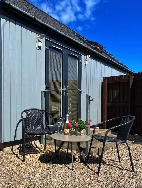 a patio with two chairs and a table in front of a building at The Annexe in Lossiemouth